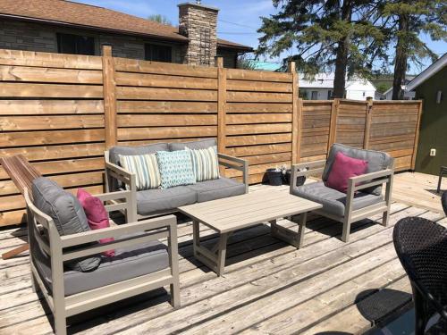 a patio with two chairs and a table and a fence at Hill Street Hangout in Picton