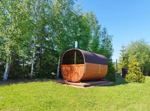 a wooden boat sitting in the grass in a field at Karumetsa Apartment in Otepää