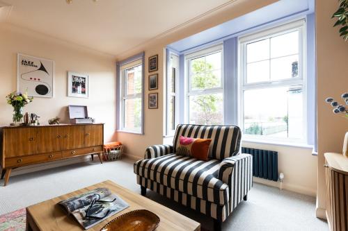 a living room with a chair and a table at The Lorelei 2BR Mid-Century Modern Stylish Apartment in Brighton & Hove