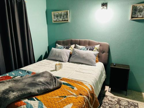 1 cama en un dormitorio con una pared azul en Fan-Ta-Sea, en Johnsons Point