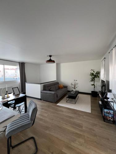 un salon avec un canapé et une table dans l'établissement HYPER CENTRE à 80m du vieux marché, T2 calme vue sur les toits Rue du Minage, à La Rochelle