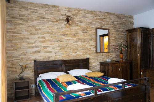 ein Schlafzimmer mit einem Bett und einer Ziegelwand in der Unterkunft Hanul Simon in Bran