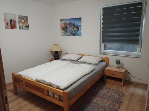 um quarto com uma cama e uma janela com uma cortina em Rose Apartmans em Jajce