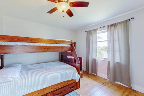 een slaapkamer met een bed, een plafondventilator en een raam bij The Cape Coral Spot in Cape Coral