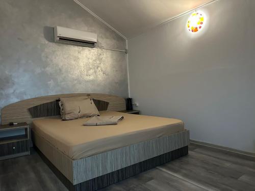 a bedroom with a bed with a air conditioner on the wall at Pensiunea Alessia Murighiol in Murighiol