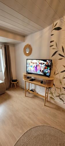 un salon avec une télévision à écran plat sur une table dans l'établissement Yescale - Le Rondeau, à La Rochelle