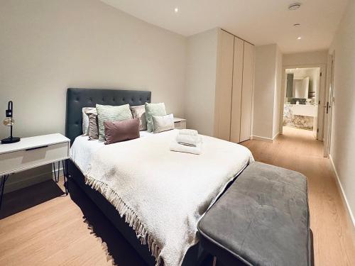 a bedroom with a large bed and a desk at Upper Riverside O2 2Bedroom Flat 05 in London