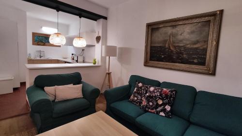 - un salon avec deux chaises vertes et une table dans l'établissement Peace & Beach House in Tihany, Sajkod, à Tihany