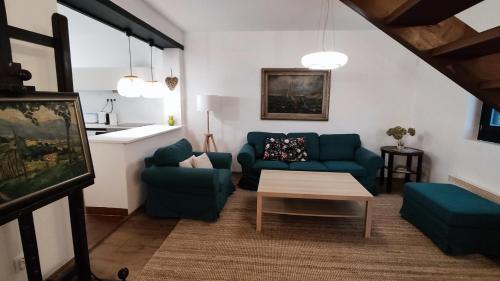 a living room with a blue couch and a table at Peace & Beach House in Tihany, Sajkod in Tihany