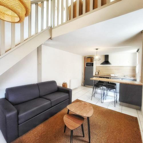 un salon avec un canapé et une table dans l'établissement Duplex cosy La petite Arche centre Pont de l'arche, à Pont-de-lʼArche