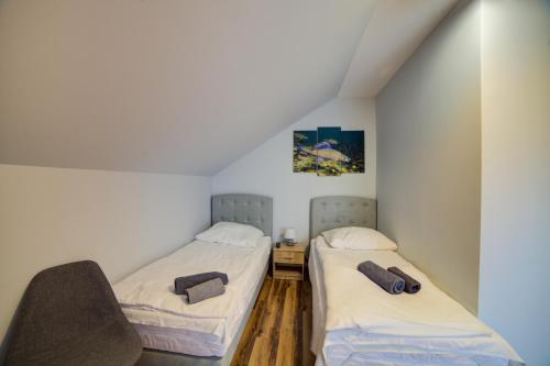 two beds in a room with white walls at Głowatka in Łączki