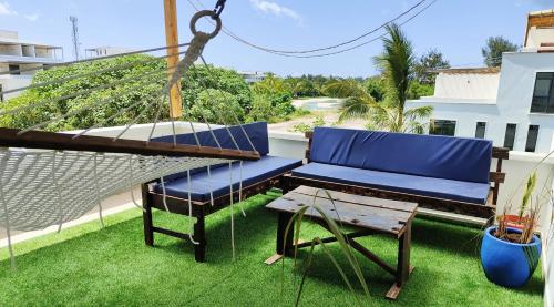 un banco colgante y una mesa en el balcón en SK Stay-Condo in The Soul with private terrace 300m Paje Beach, en Paje