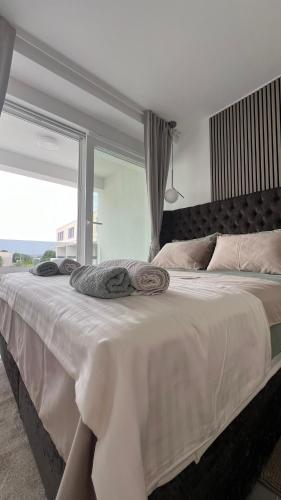 a bedroom with a large bed with a large window at Luxury apartment Black Pearl Beluga with private Pool and Jacuzzi in Novalja