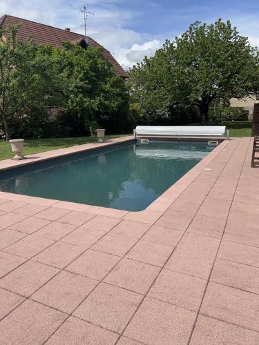 une piscine dans une cour à côté d'une maison dans l'établissement Ferme alsacienne de charme, à Erstein
