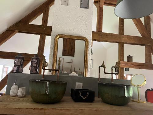 La salle de bains est pourvue de 2 lavabos verts et d'un miroir. dans l'établissement Ferme alsacienne de charme, à Erstein