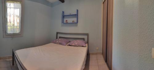 une chambre avec un lit avec deux oreillers dessus dans l'établissement Villa au calme au cœur de la pinède, au Cap d'Agde