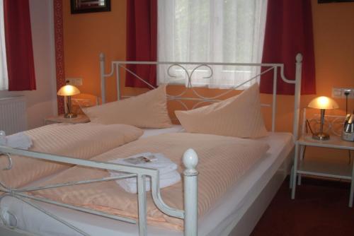 a bedroom with a white bed with white pillows at Komforthotel-Restaurant Württemberger Hof in Bad Saulgau