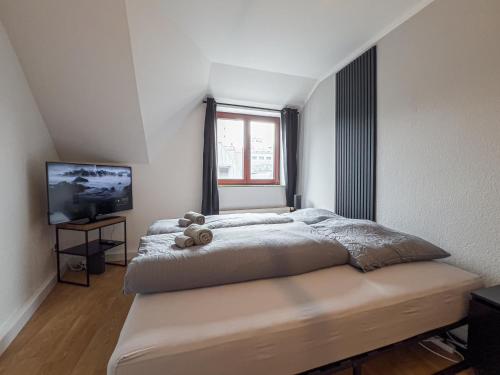 ein Schlafzimmer mit einem Bett, auf dem ein Teddybär liegt in der Unterkunft Rathausblick – Moderne Ferienwohnung mit 2 Schlafzimmern, Küche, Bad, Waschmaschine & Trockner mitten in der Innenstadt in Leipzig