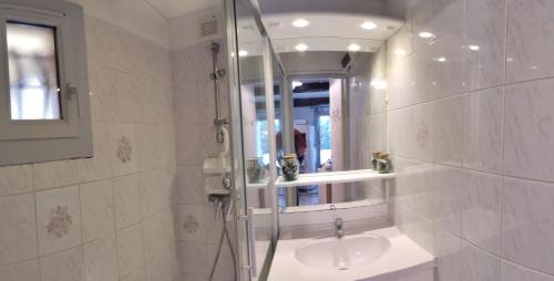 une salle de bain avec une douche, un lavabo et un miroir dans l'établissement Villa au calme au cœur de la pinède, au Cap d'Agde