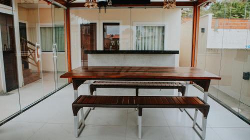 einen Holztisch und eine Bank in einem Zimmer in der Unterkunft Casa de férias nos lençóis maranhenses in Barreirinhas