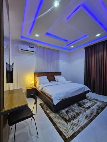 a bedroom with a bed and a table and blue lights at Genesis Grid Homes - Petra in Lekki