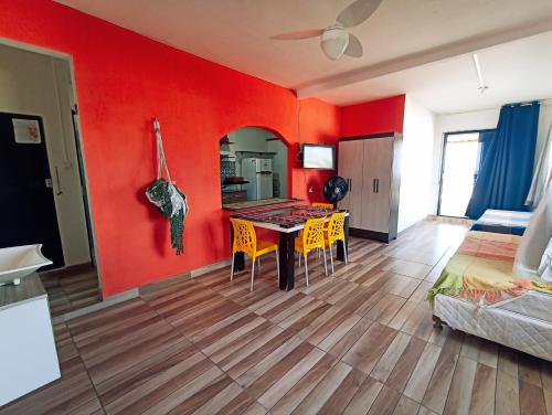 a living room with red walls and a table and chairs at Ponta Negra Suites & Apart in Natal