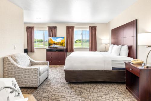 a hotel room with a bed and a chair at Boarders Inn & Suites by Cobblestone Hotels - Shawano in Shawano