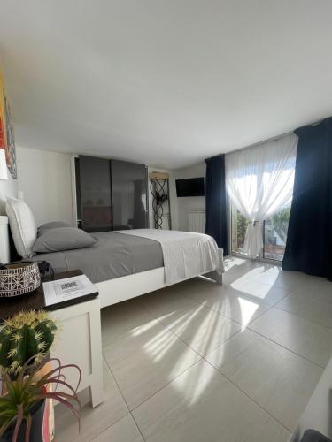 sypialnia z dużym łóżkiem i dużym oknem w obiekcie Kleos suite w mieście Bari