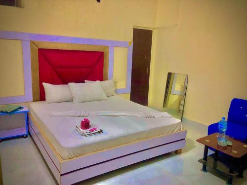 a bedroom with a large bed with a red headboard at Malinum Grande Guest House in Lahore