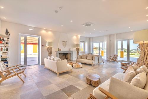 a living room with white furniture and a fireplace at Resort Rural Quinta do Carrascal in Santarém