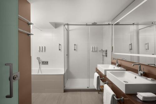 La salle de bains est pourvue de 2 lavabos et d'une douche. dans l'établissement Courtyard by Marriott Paris Porte de Versailles, à Issy-les-Moulineaux