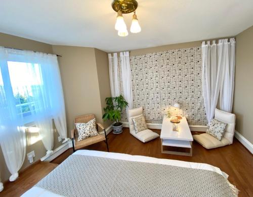 1 dormitorio con 1 cama, mesa y sillas en Gorgeous Private Estate With Ocean and Mountain View en Nanoose Bay