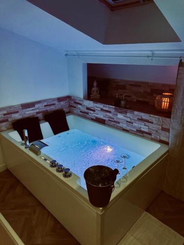 a jacuzzi tub with a table in a room at La Parenthèse Maisonnette avec Jacuzzi in Le Luc