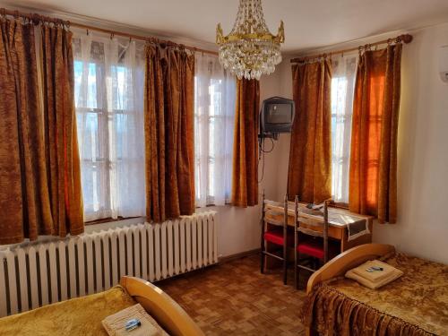 um quarto com uma mesa, cadeiras e janelas em Arbanassi Hotel em Arbanasi