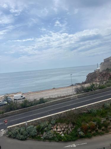 a road with a view of a beach and the ocean at Appartement vue mer in Sète