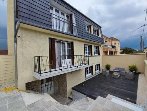 a house with a balcony and a patio at G-Logement-Francilien Aéroport CDG, Parc des expositions Villepinte, Bourget, Astérix. in Goussainville