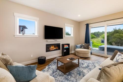 a living room with a fireplace and a tv at Pelican Cove in Westport
