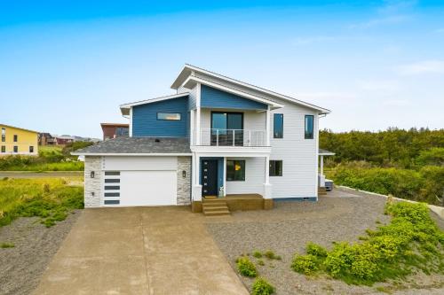 a blue and white house with a garage at Pelican Cove in Westport