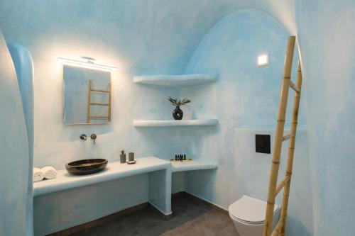 uma casa de banho azul com um lavatório e um WC em Captain's house suites em Vóthon