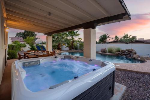 a hot tub on a patio next to a pool at Game Room Resort Pool HotTub Modern Desert Oasis in Phoenix