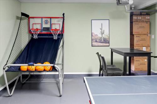 a gym with a basketball hoop and a table at Game Room Resort Pool HotTub Modern Desert Oasis in Phoenix