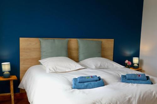 Una cama blanca con dos toallas encima. en House near beach equipped for 8 people, en Barneville-Carteret