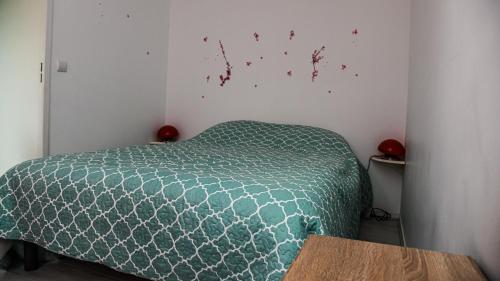 - une chambre avec une couette verte sur un lit dans l'établissement Charmant deux pièces rez de chaussée, à Cabourg