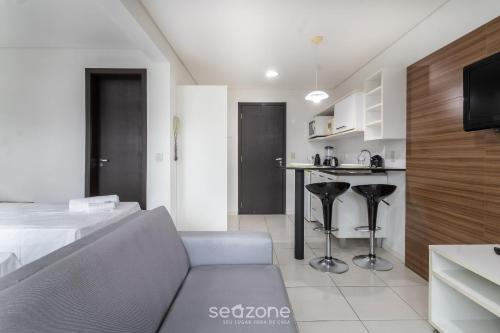 a living room with a couch and a kitchen at SPT - Studios Convenientes em Blumenau/SC in Blumenau