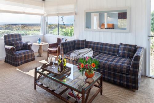 Una sala de estar con un sofá y sillas y una mesa. en Beautiful beach house 220m2 Perfectly equipped for 9 people baby, en Barneville-Carteret
