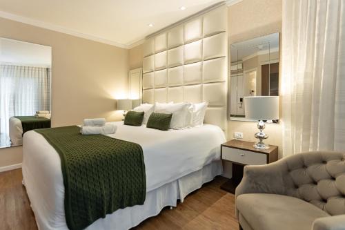 a bedroom with a large white bed and a couch at Hotel Jardins da Colina in Nova Petrópolis