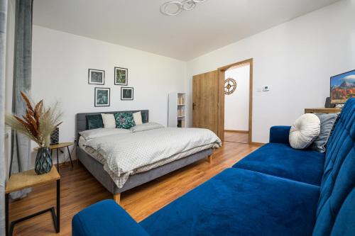 a bedroom with a bed and a blue couch at Apartmán Martin in Poprad