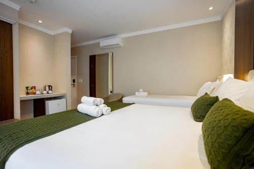 a hotel room with a bed with towels on it at Hotel Jardins da Colina in Nova Petrópolis