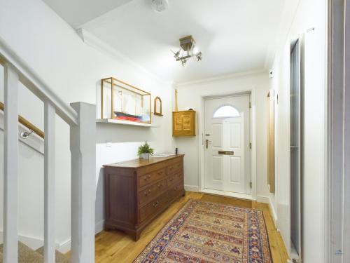 un pasillo con un tocador y una puerta blanca en Queens Mews a contemporary beach side holiday home for 6, en Ryde