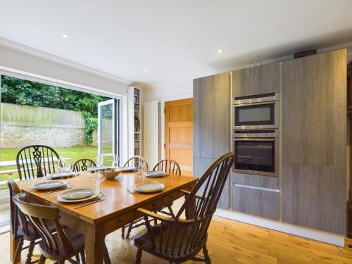 a dining room with a wooden table and chairs at Queens Mews a contemporary beach side holiday home for 6 in Ryde